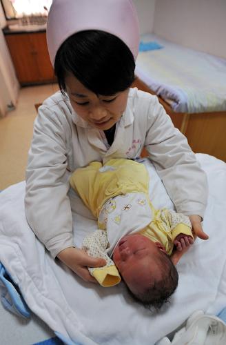 3月1日,在广西桂林市第一人民医院产科,护师孟庆在护理一名新生婴儿。当日,广西正式实施单独二孩政策。广西计生部门指出,办理单独二孩生育证程序并不复杂,如符合单独二孩条件的夫妇在今年3月1日前已怀孕尚未生育,3月1日零时以后可以按有关规定补办二孩生育证。新华社记者 陆波岸 摄